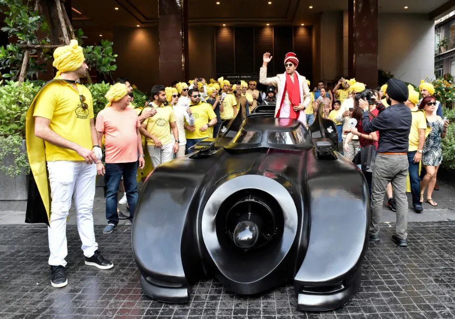 Indian wedding baraat procession with luxury car